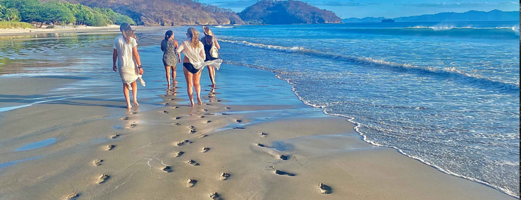 Photo of four women walking down the beach in Nicaragua